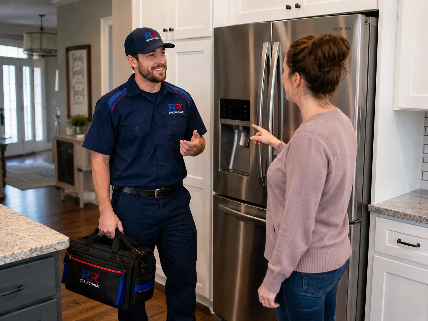 RR Springdale technician discussing refrigerator water dispenser service with a homeowner in Springdale, AR.